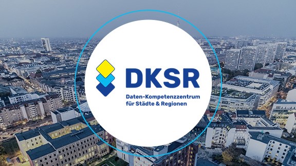 DKSR logo in front of a photo of a city from above.