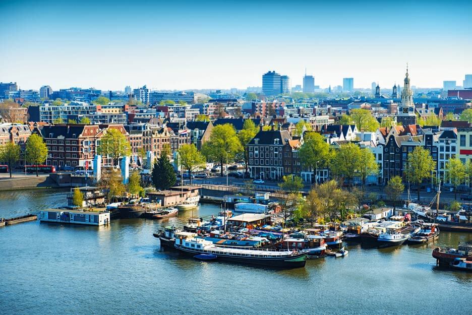 Luftbild von Amsterdam an einem sonnigen Tag mit Hafen und Gebäuden