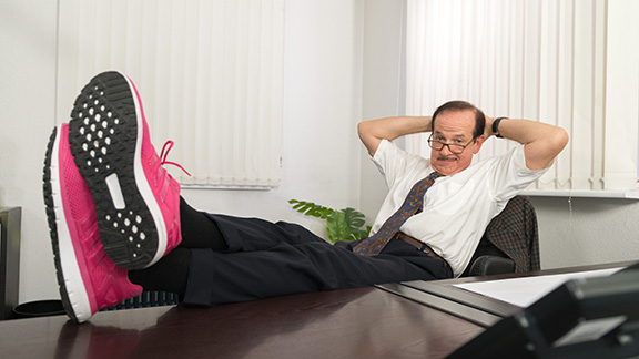 Klaus Dieter Möllenkamp am Schreibtisch sitzend, mit hinter dem Kopf verschränkten Armen und hochgelegten Beinen